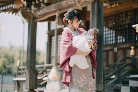 神社でのお宮参り、着物のママが赤ちゃんを抱っこしている様子